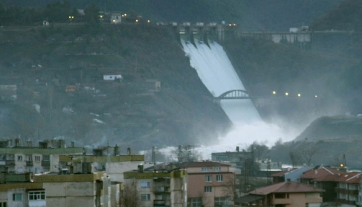 Огромни талази вода се стоварват с грохот от язовирната стена, но не стряскат любопитните зрители