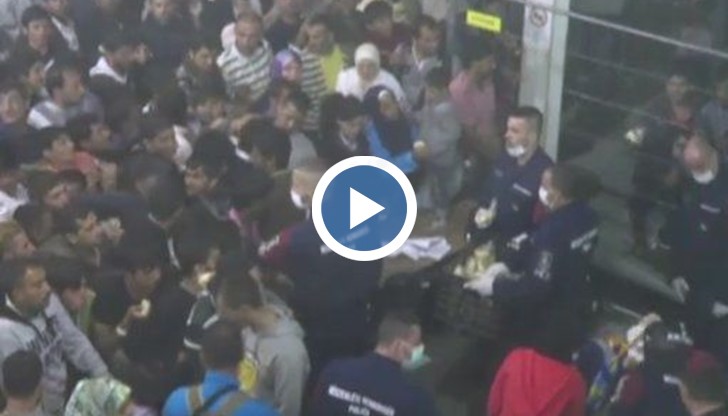 Видеозапис показа как полицаи хвърлят храна на тълпа имигранти в лагер