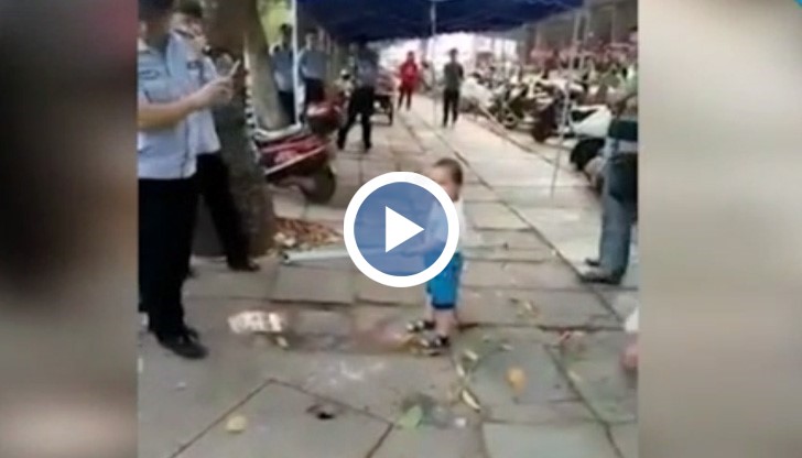 Властите се опитват да затворят уличната сергия на бабата на момченцето. То грабва метална тръба и се опитва да я защитава