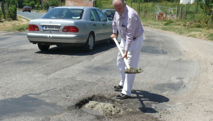 Доцент Борислав Великов ремонтира дупките на пътя на входа на Лом