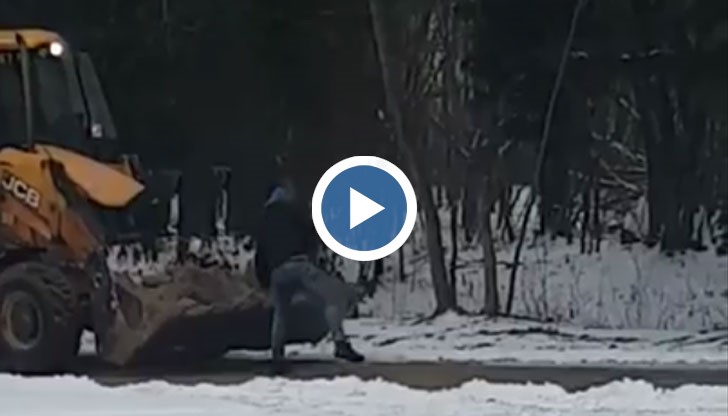 Двама души хвърлят пясък с лопати от греблото на багер