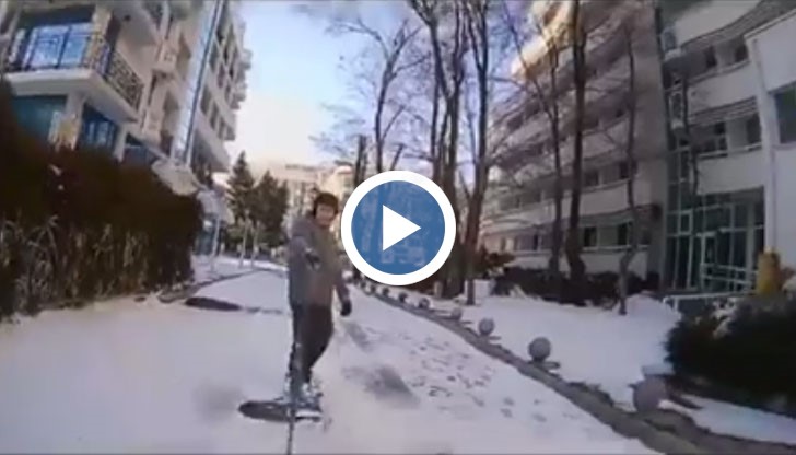 Руснак кара сноуборд по крайбрежната алея в Слънчака