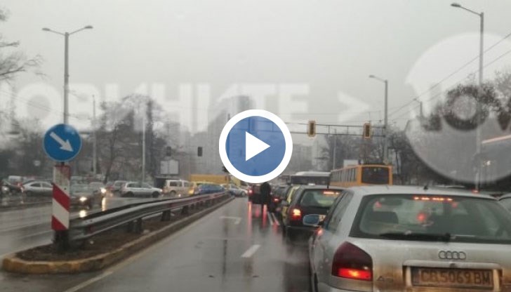 Шофьор излезе в поройният дъжд, за да регулира движението по натоварено кръстовище