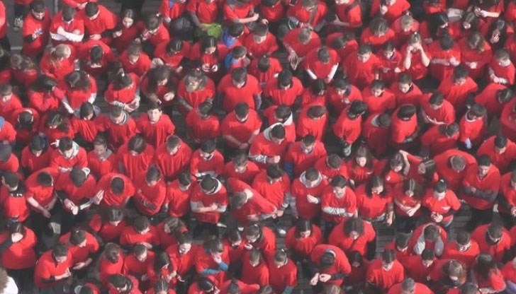 600 деца, облечени в бели и червени тениски, образуваха...