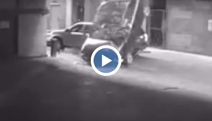 Летящата кола преминава през бариерите, блъска се в отсрещната сграда, приземява се върху предницата си и след това се преобръща