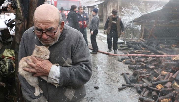 Възрастният мъж и любимецът му гледат как изгаря домът им в село в провинция Орду