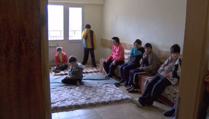 Санитарите носят палки, хората лежат покрити с мухи, а подът е наводнен от урина и покрит с изпражнения