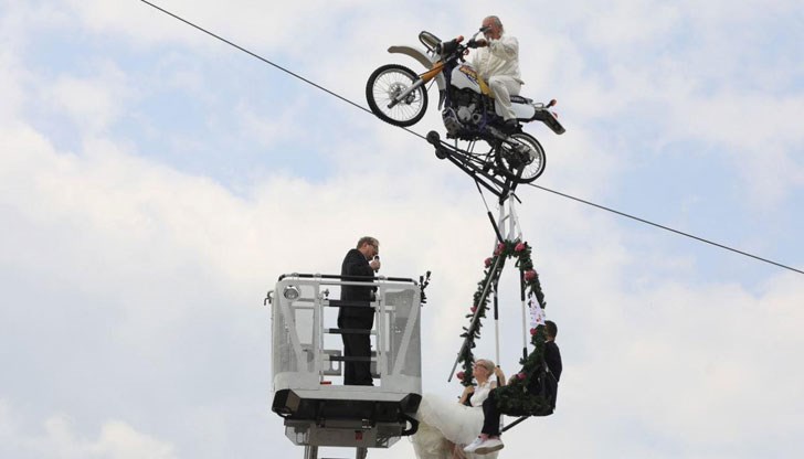 Младоженците са в люлка, висяща от мотор, крепящ се върху опънато въже на 14 м височина