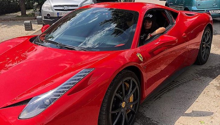 Певицата позира, седнала на шофьорското място на червено ферари Певицата позира, седнала на шофьорското място на червено ферари