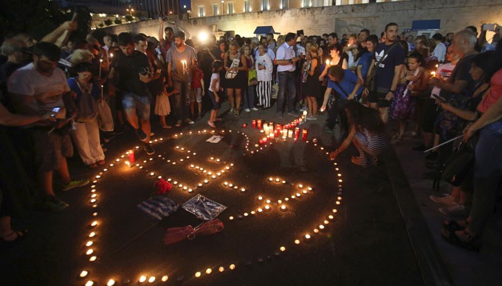 Стотици гърци се събраха снощи на бдение в памет на жертвите на пожарите, пламнали край Атина преди седмица