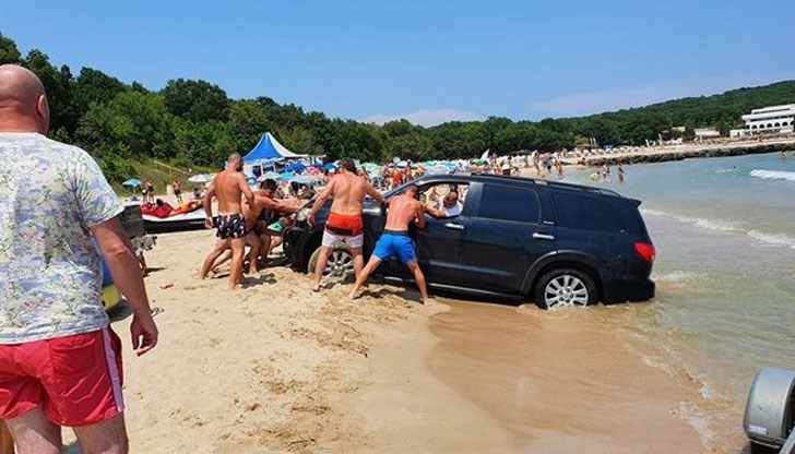 Група момчета се мъчат да извадят от пясъка, заседнал джип близо до водата на плаж Перла