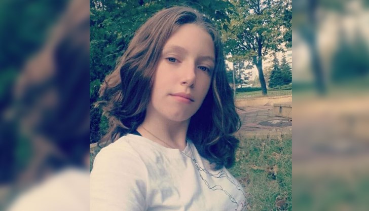 Момичето е с тъмноруса коса, сини очи, облечена е с черно яке и сив клин с черна лента Момичето е с тъмноруса коса, сини очи, облечена е с черно яке и сив клин с черна лента