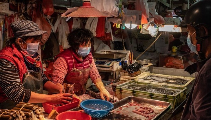 Вей Гуиксиан е продавачка на живи скариди на пазара за морски продукти
