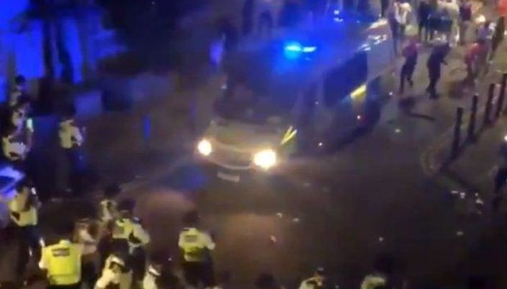 От кадрите се вижда как присъстващите нанасят щети на полицейски автомобили и хвърлят бутилки по полицаи