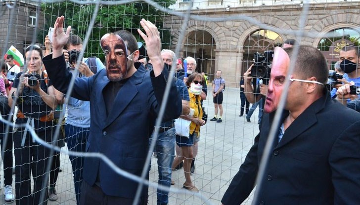 Десетина души с бели маски на лицата и обозначени като представители на различни професии - медицинска сестра, музикант, строителен работник, спортист символично "затвориха" в клетка други хора с маски на премиера Бойко Борисов и на главния прокурор Иван Гешев