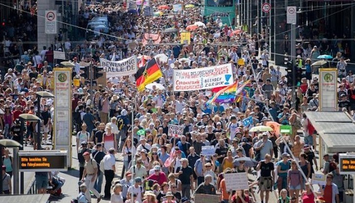 Тълпа от хора, много от които не носеха маски, марширува от Бранденбургската врата по широкия булевард, който минава през градския парк „Тиргартен". Демонстрацията беше озаглавена „Краят на пандемията: ден на свободата"