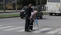 Полицай помага на възрастна жена да пресече
