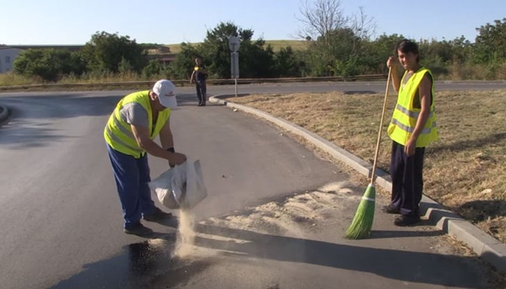 Замърсеният пътен участък е посипан с подходяща смес за абсорбиране на масления разлив Замърсеният пътен участък е посипан с подходяща смес за абсорбиране на масления разлив