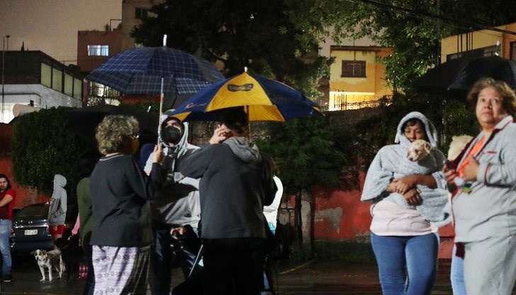 Хората се струпаха заедно под дъжда, с малки деца и домашни любимци в ръце, твърде изплашени, за да се върнат по домовете си след силния трус Хората се струпаха заедно под дъжда, с малки деца и домашни любимци в ръце, твърде изплашени, за да се върнат по домовете си след силния трус