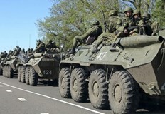 Между жилищни блокове в град Бердянск се вижда руски БТР