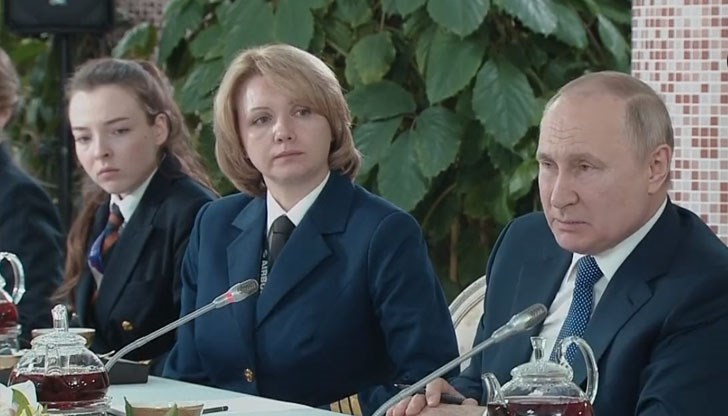 Ръката на руския президент минава през микрофон, присъстващите гледат над главата му, а в чайника пред него не се отразяват никакви хора