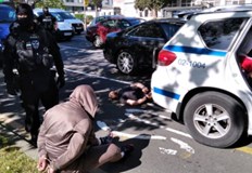 Двама души са с белезници на пътното платноЗрелищен арест на