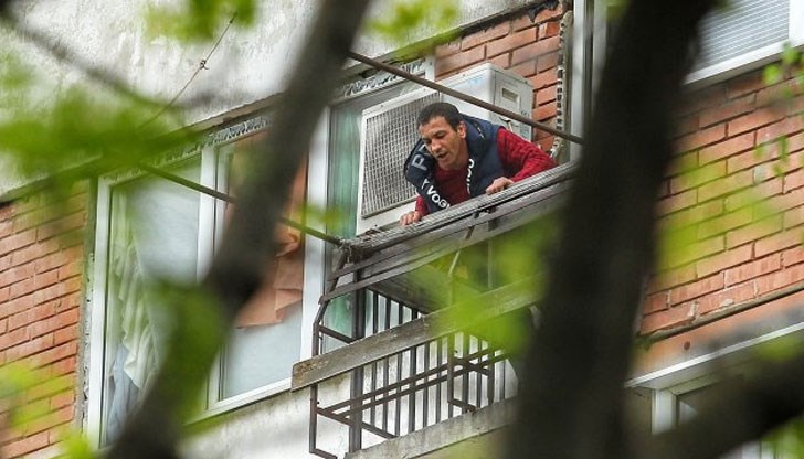 Присъствието на полиция и журналисти не го притеснява, продължава да се показва на прозореца с виковe и заплахи