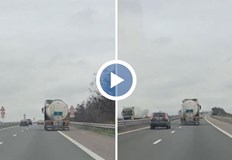 Шофьорът полага усилия да държи голямото превозно средство в дясната