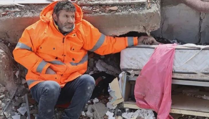 Баща държи безжизнената ръка на дъщеря си, затисната под бетонните