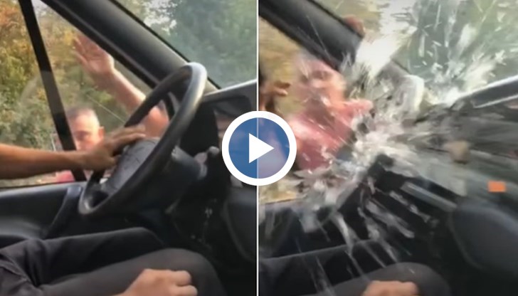 Мъж разбива прозорец на бус с ръцете си, докато шофьорът на превозното средство е вътре