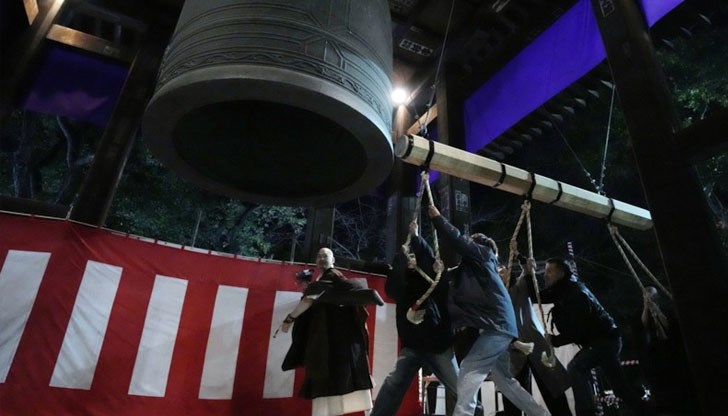 Хората бият гигантска камбана, за да отпразнуват Нова година в будистки храм, минути след полунощ в понеделник, 1 януари 2024 г., в Токио, Япония