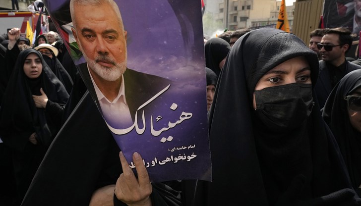 Иранка на погребението на лидера на "Хамас" Исмаил Хания, която държи банер с надпис "Поздравления, Хания!" Иранка на погребението на лидера на "Хамас" Исмаил Хания, която държи банер с надпис "Поздравления, Хания!"